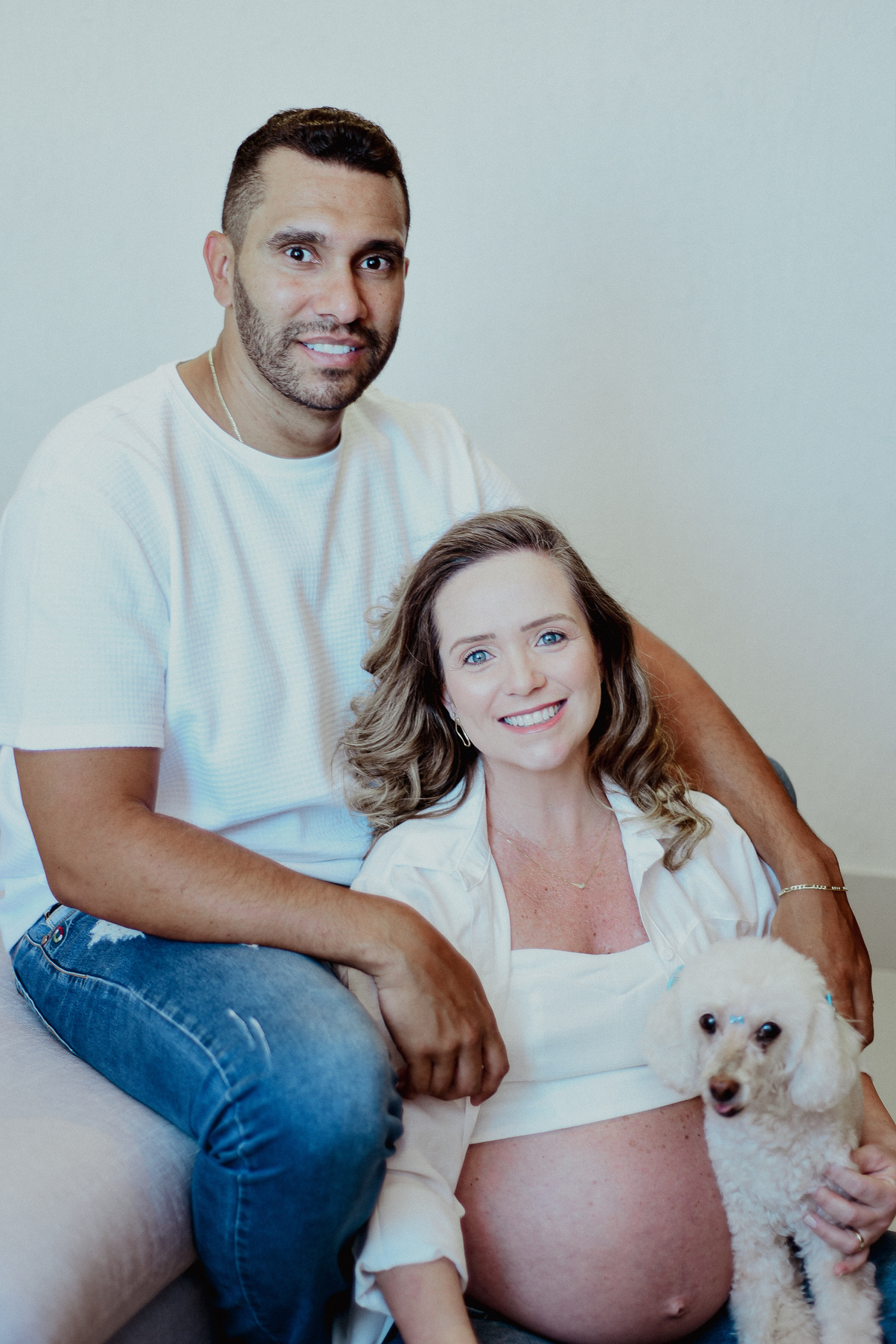 Casal grávido em casa com seu cachorrinho poodle