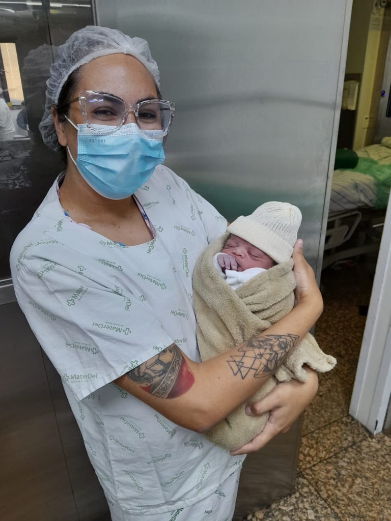 Ráimes Souza na maternidade segurando um recém-nascido